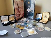 Group view of boxed sets, cased medals and loose coins