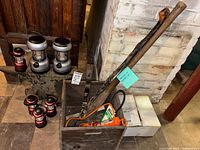 overall lot with lanterns on wall, red lanterns on floor, crate with strap and staff