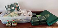 Overview showing tub of coins, coin folders, presentation boxes, display board and figurines