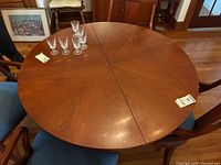 Top view of round mahogany veneer table showing center split and surface condition