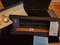 Both Stauer watches in their presentation boxes with certificates visible