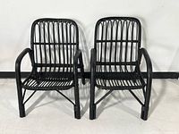 Front view of both black rattan armchairs