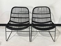 front view pair black rattan lounge chairs