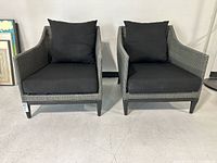 Both resin wicker lounge chairs with black cushions shown (cushions not included).