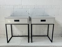 Front view of both matching grey side tables showing drawers and metal bases