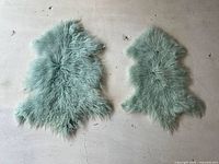 Both lambskin rugs laid side by side showing full shapes and color