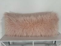Front view of powder pink faux fur lumbar pillow