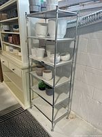 Full view of shelf angled left, shows chrome frame and six white shelves