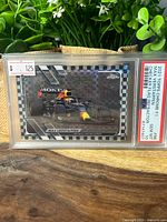 Front of PSA-slabbed Max Verstappen checker flag refractor card