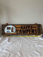 Front view of entire wood sign with text and metal camper