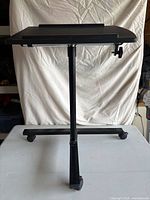 Full view of black adjustable rolling desk