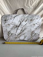 Front view showing marble-look top surface, handle, with tape measure indicating width