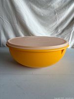 Side view of yellow Tupperware bowl with pale lid attached