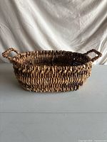 Front view of oval wicker basket showing overall shape and handles