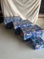 Four closed boxes in size order showcasing exterior pattern