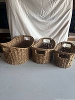 Three wicker baskets side by side showing size difference and handles