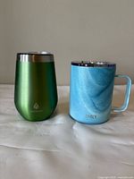 Both mugs side by side showing colors, shapes, and lids