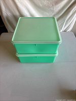 Stacked view of two square jadeite green Tupperware containers with lids