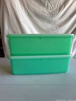 Two stacked jadeite green Tupperware containers with lids in place