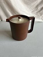 Side view of brown Tupperware pitcher with lid in place