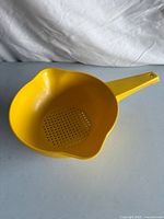 Full view of yellow Tupperware strainer