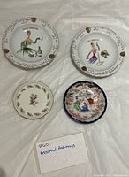 Top view of four porcelain ashtrays displaying designs and condition