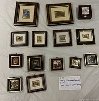 All 14 framed plaques and certificate sheet laid flat on white background