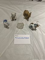 Five assorted elephant figurines laid out on table