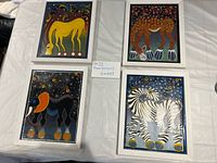 Front view of all four framed artworks showing animal subjects and colour tones