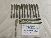 Twelve spreaders and one nutcracker arranged on surface with note card