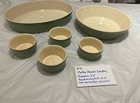 Full set overview showing oval baker, round bowl, four ramekins