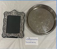 Front view of silver-plated round tray and ornate photo frame