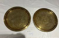 Front view of both engraved brass trays showing detailed motifs and size reference note
