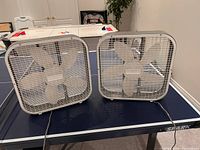 Both Holmes box fans side by side on table