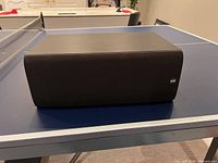 Front-left angle view of entire speaker showing grille and cabinet condition