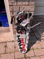 Full view of new Yukon Charlies snowshoe kit leaning against wall showing snowshoes, poles, bag and hang tag