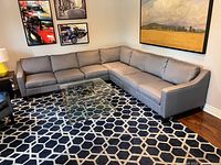 Full view of grey L-shaped sectional on geometric rug