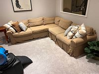 Full view of beige Pottery Barn sectional with pillows