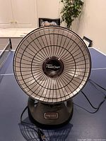 Front view of Presto HeatDish heater showing reflector dish, grille, base and power cord