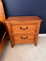 Front view of wood nightstand, two drawers with metal handles