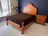 Full view of assembled wood double bed frame showing headboard, footboard and side rails