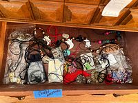 Drawer containing multiple corded necklaces with varied pendants