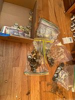 Overview of bags of coins and bills in box on floor