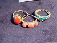 All three gold rings on dark surface