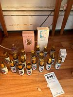 Group shot showing all perfume items on floor including two sealed boxed perfumes, multiple Old Spice minis, atomizer, small boxed fragrance