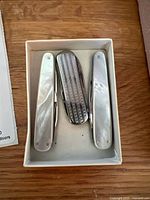 Three pocket knives in box, closed