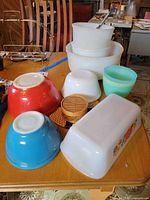 Assorted bowls, loaf dish, tumbler and trivets on table