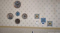 Overall view of wall displaying round plates, star tile and square trivets