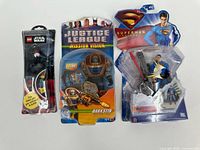 Group shot of all three sealed action figures and the watch in packaging