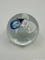 Full view of glass paperweight showing interior colors and bubbles